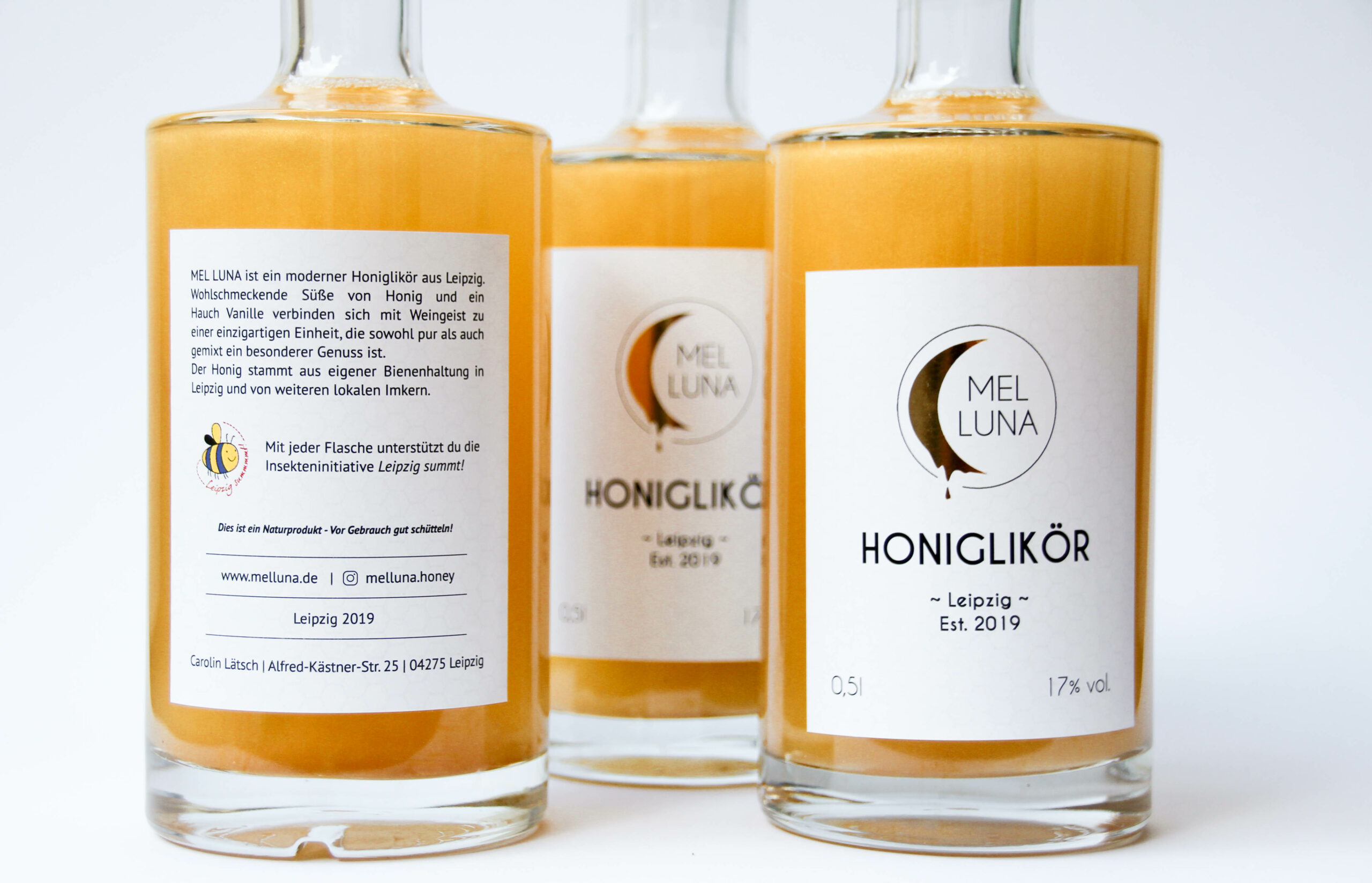 Drei Flaschen Honiglikör vor weißem Hintergrund